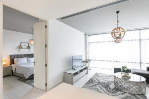 a white bedroom with a bed and a table at Extraordinary Burj Khalifa View, 1 Bedroom Index Tower DIFC in Dubai