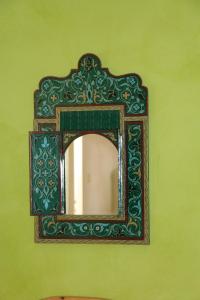 a mirror with a green frame on a green wall at Riad Les Chtis D'Agadir in Agadir