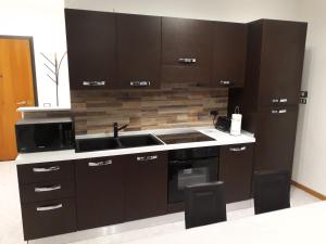 a kitchen with dark brown cabinets and a sink at Elite Apartments in Perugia