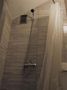 ducha con cabezal de ducha y cortina de ducha en Jurgis Guest house, en Kaunas