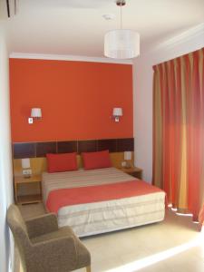 1 dormitorio con cama y pared roja en Mantamar Apartamentos, en Manta Rota