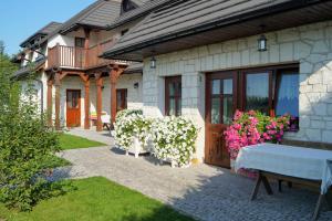 una casa con una mesa y flores delante de ella en Miło,Tu, Pokoje Gościnne en Kazimierz Dolny