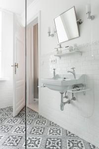 La salle de bains blanche est pourvue d'un lavabo et d'un miroir. dans l'établissement B&B La Passion Interdite, à Ostende
