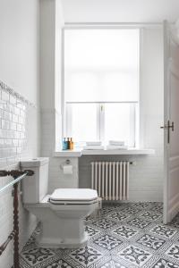 a white bathroom with a toilet and a window at B&B La Passion Interdite in Ostend