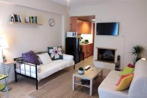 ein Wohnzimmer mit 2 Sofas und einem Kamin in der Unterkunft Aloe apartment in Askeli in Poros