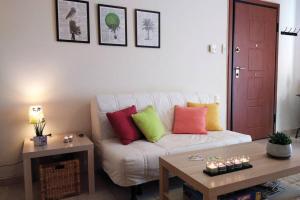 ein Wohnzimmer mit einer weißen Couch mit bunten Kissen in der Unterkunft Aloe apartment in Askeli in Poros