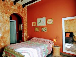 1 dormitorio con 1 cama y pared de color naranja en Hostal Artistic B&B, en Madrid