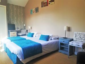 a hotel room with two beds with blue sheets at Logis Hotel Restaurant l'Orée Des Bois in La Breille-les-Pins