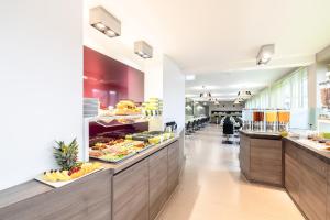a kitchen filled with lots of different types of food at Hotel Demas City in Munich