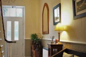 a living room with a couch and a lamp at West End Guest House in Richmond