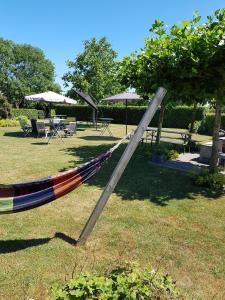 a hammock in the grass in a park at B&B Biesehof in Kapelle