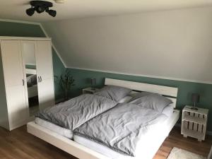 ein Bett in einem Schlafzimmer mit einer grünen Wand in der Unterkunft Ferienwohnung Eulenhof -direkt an der Este in Jork