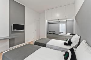 a hotel room with two beds and a kitchen at BAG- Boutique Apartment Grey - Hilton Area in Athens