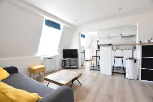 un soggiorno con divano e cucina di Appartement Dunkerque Centre a Dunkerque