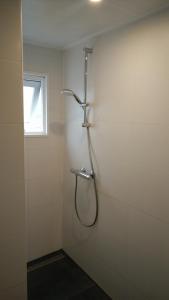 een douchecabine in een badkamer met een raam bij Modern en compleet chalet 22-15 in Putten