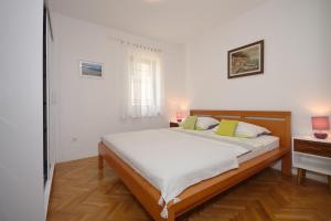 ein Schlafzimmer mit einem großen Bett und einem Fenster in der Unterkunft Apartment with terrace and sea view in Mali Lošinj