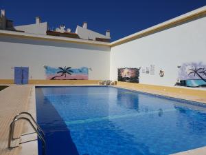 a large swimming pool with blue water in a room at Albufeira Falesia Beach Apartment in Albufeira