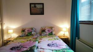 een slaapkamer met een bed met bloemen erop bij Modern en compleet chalet 22-15 in Putten