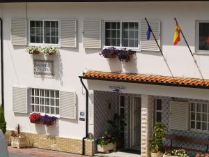 a white building with flower boxes and windows at Residencial Celeste in Águeda