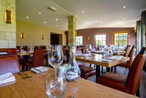 a restaurant with empty wine glasses on a wooden table at Dornoch Castle Hotel in Dornoch