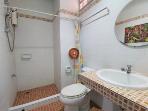 a bathroom with a sink and a toilet and a mirror at Baan Por Jai in Ko Lanta