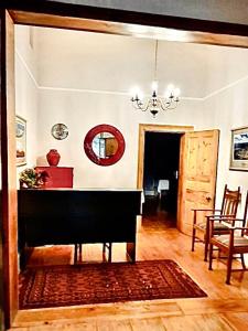 un soggiorno con pianoforte e tavolo di De Graaff Manor a Graaff-Reinet