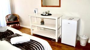 un comodino bianco con un piccolo frigorifero in camera di De Graaff Manor a Graaff-Reinet