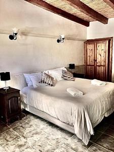 una camera da letto con un grande letto bianco e un tavolo di De Graaff Manor a Graaff-Reinet