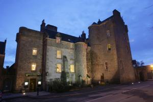 an old castle is lit up at night at Dornoch Castle Hotel in Dornoch