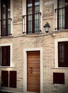 un edificio de ladrillo con puertas y ventanas de madera en M Suite en San Benedetto del Tronto