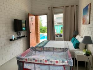 a bedroom with a bed and a tv and a pool at Casa Tanjung Jara in Dungun