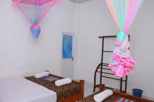 2 camas en una habitación con cortinas y una habitación con 2 camas en Leesa Villa Safari Resort, en Udawalawe