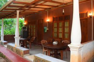 una casa con patio con mesas y sillas en Leesa Villa Safari Resort, en Udawalawe