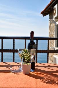 a bottle of wine and a plant on a table at Apartments Susanna in Ulcinj