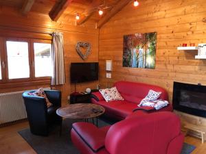 ein Wohnzimmer mit einem roten Sofa und einem TV in der Unterkunft Romantikhütten 1 & 24 in Stamsried