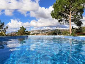 una piscina azul con un árbol en el fondo en Villa Gavriel - Peyia Villa With Breathtaking Sea View, Peyia Villa With Private Pool, Secluded, Huge Outdoor Space, Mountain Views en Peyia