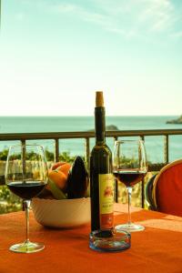 uma garrafa de vinho e dois copos numa mesa em Apartments Susanna em Ulcinj