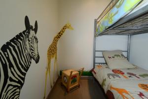 a bedroom with a zebra and a giraffe on the wall at Le Moulin d'Harcy in Lonny