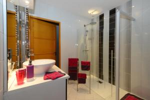 a bathroom with a sink and a glass shower at Les étangs du moulin d'Harcy in Lonny +18 photos