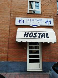 Hostal Doña María في فالديمورو: علامة مستشفى على باب مبنى من الطوب
