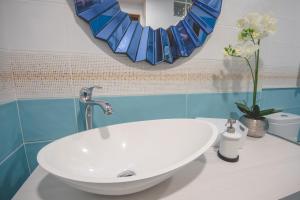 uma casa de banho com um lavatório branco e um espelho. em Apartamentos Coso de San Albin em Mérida