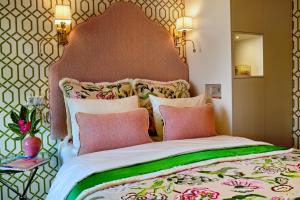 a large bed with pink and green sheets and pillows at Hotel Estheréa in Amsterdam