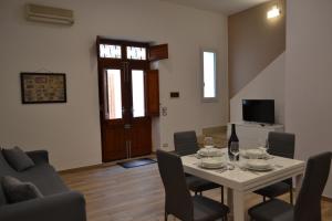 ein Wohnzimmer mit einem Tisch und Stühlen sowie einem TV in der Unterkunft Appartamento del Golfo in Castellammare del Golfo