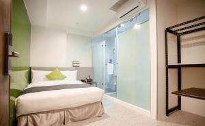 a bedroom with a bed and a glass shower at T.O. Hotel - Taipei station in Taipei