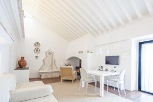 a white living room with a white table and chairs at Torre de Palma Wine Hotel - Design Hotels in Monforte