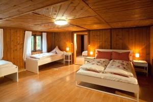 1 Schlafzimmer mit 2 Betten in einem Zimmer mit Holzwänden in der Unterkunft Wald-Ferienhaus-Seefried in Immenstadt im Allgäu