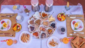 a table with plates of breakfast food on it at Riad Rihana Dades in Boumalne