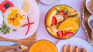 a table with a plate of fruit and a bowl of eggs at Riad Rihana Dades in Boumalne