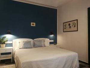 1 dormitorio con cama blanca y pared azul en Kosbor Panzió, en Magyarszombatfa