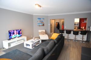 a living room with a couch and a tv at Knokke luxury appartement in Knokke-Heist